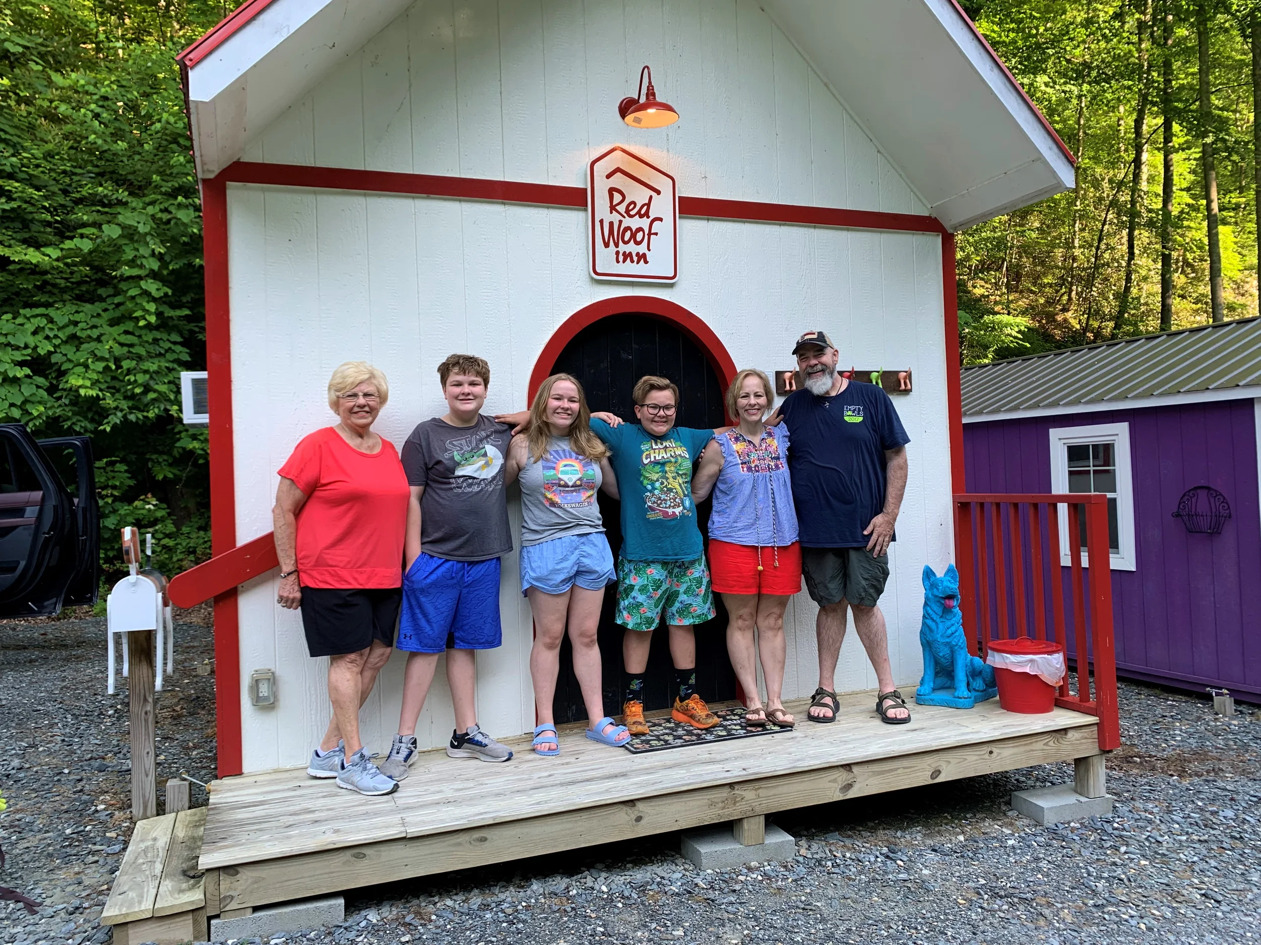 Family of five having a photo op in front of the Red Woof Inn