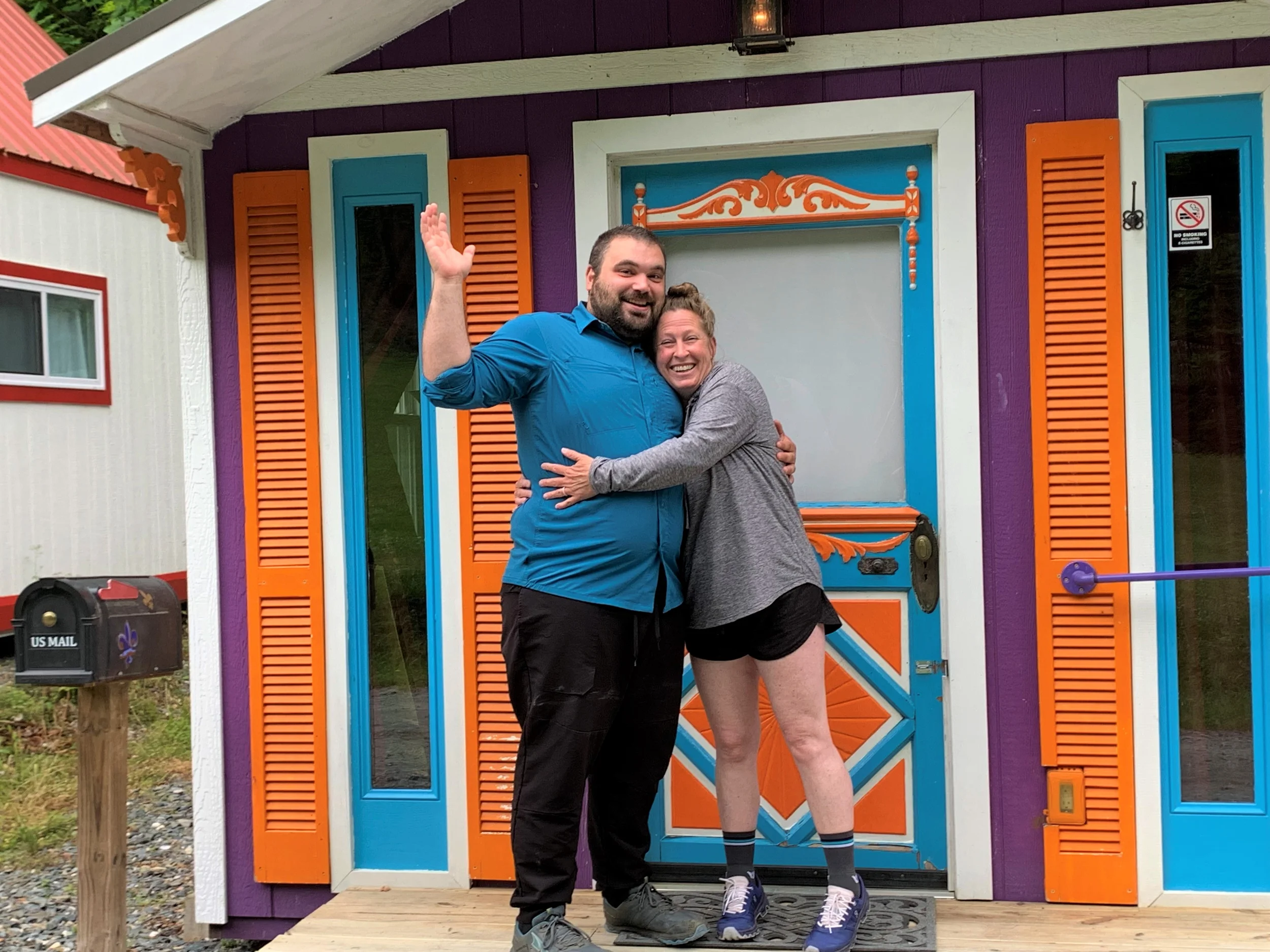 Couple hugging in front of New Orleans themed tiny house